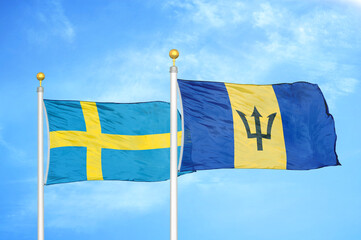 Sweden and Barbados two flags on flagpoles and blue sky