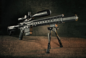 Studio shot of an AR-15 Rifle with warm lighting, on a bipod with a silencer and optic.