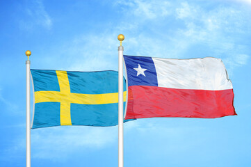 Sweden and Chile two flags on flagpoles and blue sky