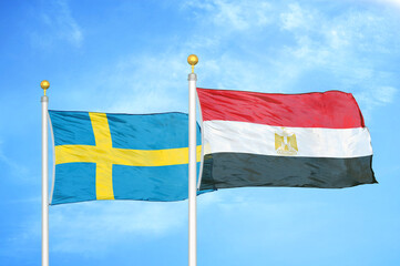 Sweden and Egypt two flags on flagpoles and blue sky