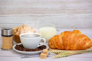 Breakfast in the morning with black coffee cup with bread with Croissant and fruit on the wooden table.