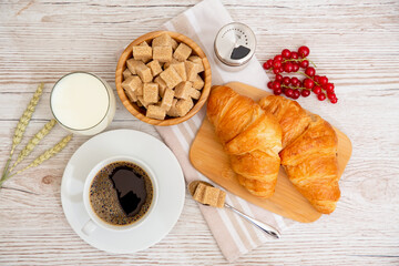 Breakfast in the morning with black coffee cup with bread with Croissant and fruit on the wooden table.