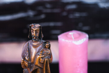 catholic saint statue with candle in the background