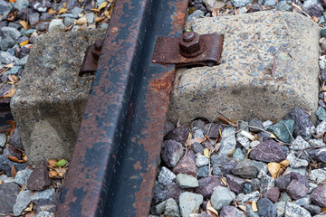 old rusty rail part of the way on a background of gravel and cement substrate