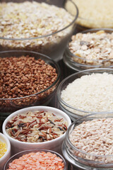 A set of bowls filled with different seeds: buckwheat, rise, corn and oatmeal