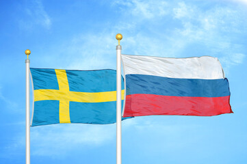 Sweden and Russia two flags on flagpoles and blue sky