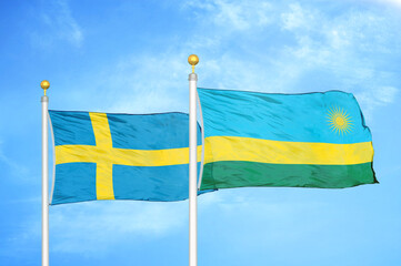 Sweden and Rwanda two flags on flagpoles and blue sky