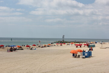 Fototapeta premium People on the beach under orange umbrellas