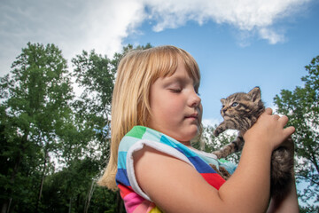 Young girl holding pet tabby kitten