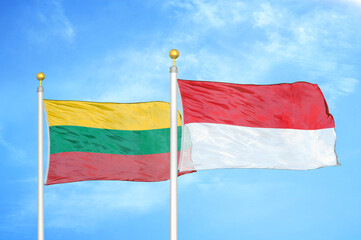 Lithuania and Indonesia two flags on flagpoles and blue sky