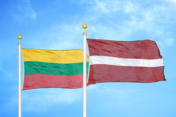 Lithuania and Latvia two flags on flagpoles and blue sky