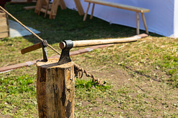 metal ax a pair of big and small stuck in a wooden log summer camping