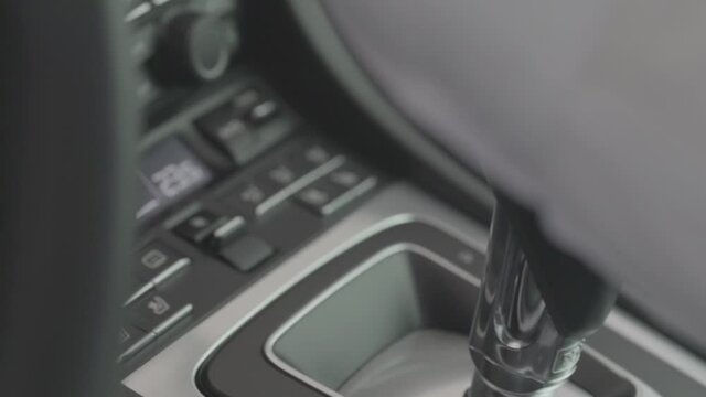 Business man in suit hand control the stick shift transmission in luxury car. Male hand changing gear driving car.