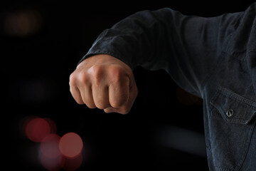 big male fist of an aggressive person is threateningly brought up for a blow, the concept of...