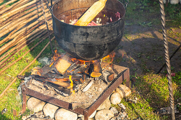 cooking stew on an open fire an iron cauldron hanging on a hook