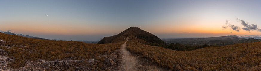 Fototapeta premium Panoramic view of a path in the middle that leads to the top of a mountain while sunset