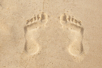 a pair of parallel footprint man on the yellow sand vacation on a tropical island