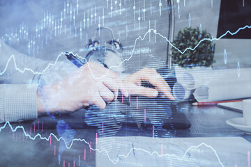 Double exposure of man's hands holding and using a phone and financial graph drawing. Analysis concept.