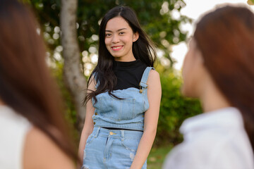 Three young Asian women as friends together at the park