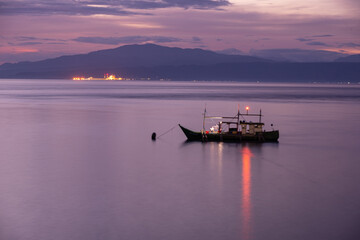 Naklejka premium fishing boat at sunset