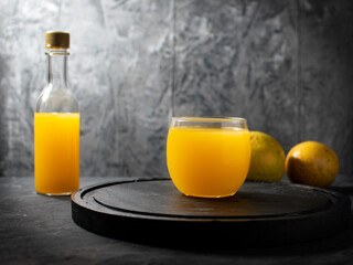 Orange juice in a glass on a black wooden table