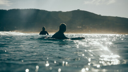 two surfer girls talking in the sea