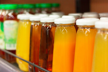 Glass bottles of juice on counters in a supermarket