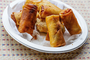 fried spring rolls lie on a white plate close up, street food of asia vietnam and thailand