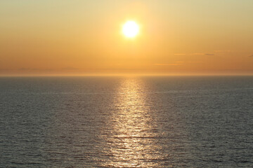 Naklejka premium Midnight sun creating lens flare in the arctic circle, Norwegian Sea, Norway