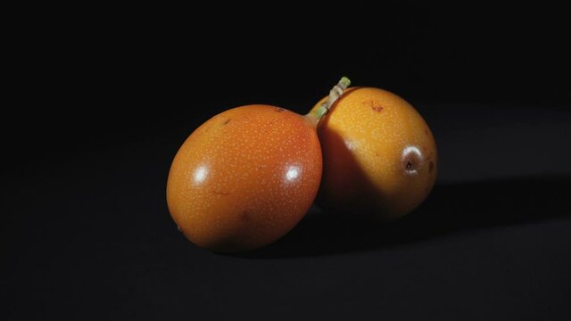 Shooting of rotating exotic granadilla on black background