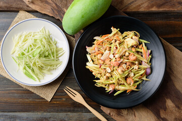 Thai food (Yum Mamuang), Spicy green mango salad on wooden background