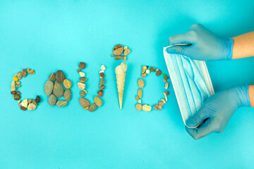 inscription corona virus from sea pebbles, a symbol of summer 2020, the concept of a summer holiday in a pandemic and isolation, the fight and protection against the virus