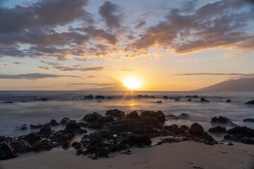 Obraz premium Sunset on beach in Hawaii Maui Long exposure of waves coming in with sand .