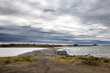 Arctic Ocean Beachfront in  Tuktoyaktuk with Pingo in the  distance with crazy clouds 