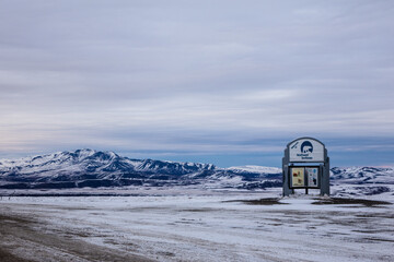 Welcoming sign to the Northwest Territories after snowfall on Dempster Highway Closeup with Mountains behind 