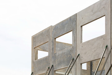 building under construction with concrete panels supported by props