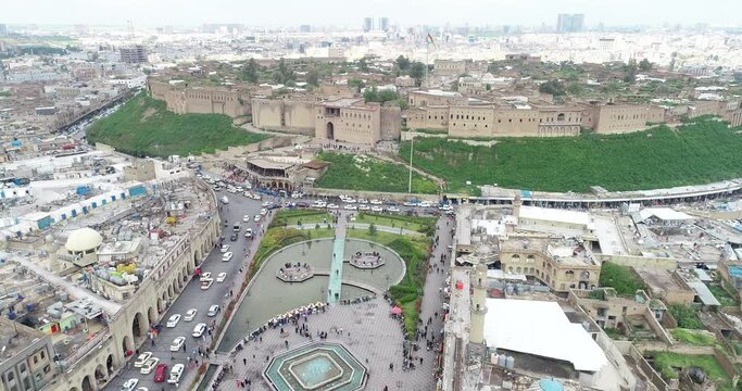 Aerial drone view of city of Erbil. Clock tower, buildings, roads, people.