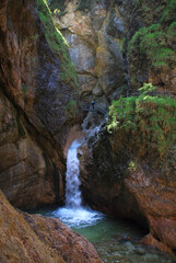 Fototapeta na wymiar photographer at Almbachklamm taking pictures of waterfall in a narrow gorge