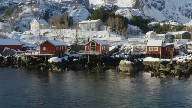 famous multicolored wooden fishing houses rorbu on a sea shore