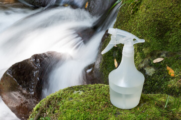 沢をバックに緑の苔の上のスプレー容器