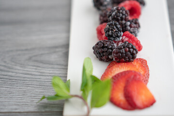 Frutos rojos presentados sobre plato de porcelana blanco rectangular