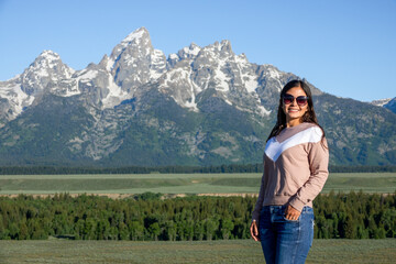 Naklejka premium Portrait of young woman posing with a view of Grand Tetons in Wyoming, USA