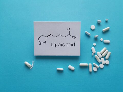 Structural chemical formula of alfa lipoic acid molecule with pills. Lipoic acid (ALA, Thioctic acid) is an organosulfur compound, antioxidant, enzyme cofactor; used as a dietary supplement.