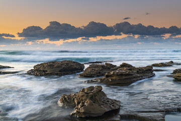 Fototapeta na wymiar Sunrise Seascape with a low cloud bank and waves