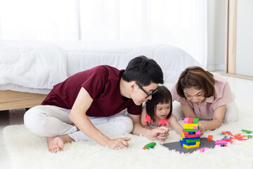 Disabled the kid and father, mother playing together with wooden toys.