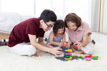 Disabled the kid and father, mother playing together with wooden toys.