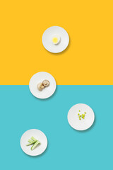 Healthy eating minimalist pattern. White plates with diet food on a yellow-blue background. Diet for weight loss.