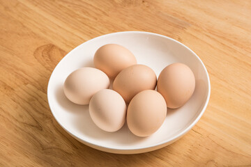 A dish of fresh earthy eggs on the wood-grain table