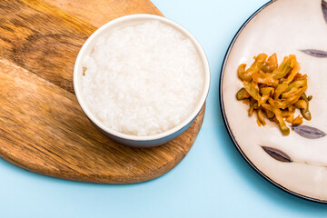 A bowl of white porridge with pickled vegetables