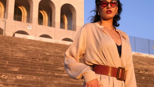  beautiful woman in diva attitude going down the stairs of square coiiseum   